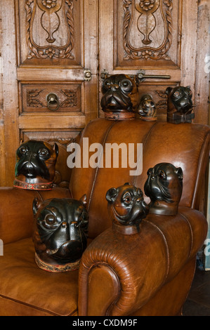Geschnitzte Obsthölzern Hunde Kopf Tabak Gläser auf französische Art Deco Sessel mit einer geschnitzten Teak Türen aus Rajasthan Stockfoto