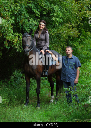 Ein schöner Bauernhof paar posiert mit ihrem Lieblingspferd. Stockfoto