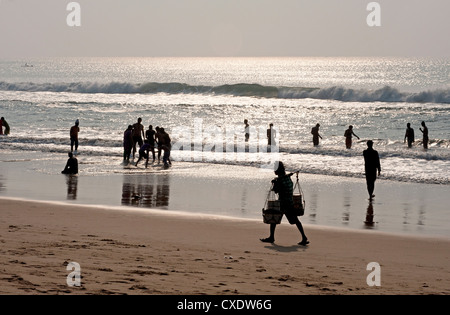 Puri Strand an der Bucht von Bengaln Familien entspannen und paddeln, Strand-Anbieter zu Fuß durch den späten Nachmittag, Puri, Orissa Stockfoto