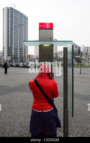 Berlin, eine Frau an einer öffentlichen Telefonzelle Stockfoto