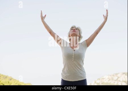Reife Frau tun Sonnengruß Stockfoto