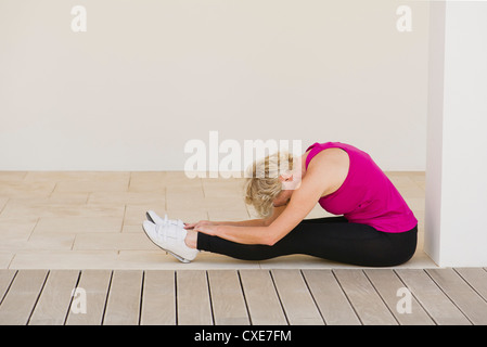 Reife Frau dabei sitzen nach vorne beugen pose Stockfoto