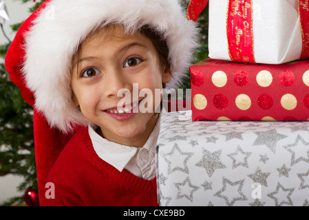 Junge mit Stapel von Weihnachten Geschenke, Porträt Stockfoto
