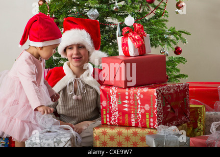 Junger Bruder und Schwester bereitet sich auf Weihnachtsgeschenke geöffnet Stockfoto