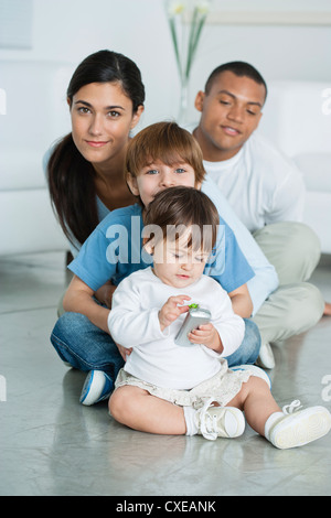 Mutter und Kinder sitzen auf dem Boden zu Hause Stockfoto