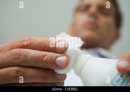 Man gießt auf Wattebausch antiseptische Stockfoto