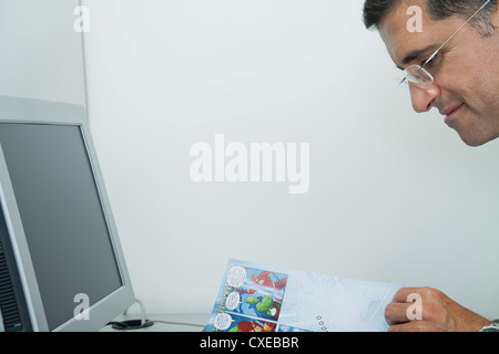 Reifer Mann Comic Buch im Büro Stockfoto