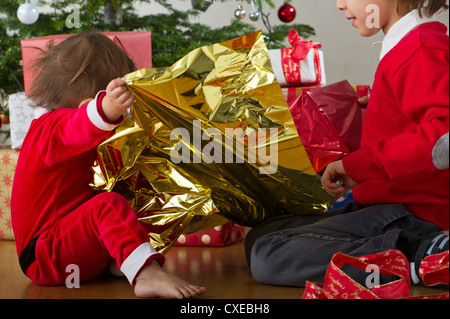 Junger Bruder und Schwester zusammen Weihnachtsgeschenke zu öffnen Stockfoto