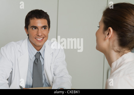 Arzt gegenüber Patientin sitzt Stockfoto