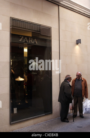 Cadiz, Männer warten vor einer Frauen boutique Stockfoto