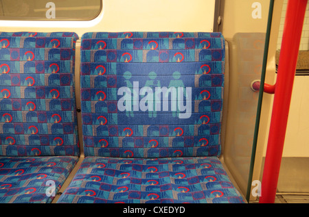 Sitzbezügen auf Sitzplatz reserviert für Passagiere, die mit einem Kind schwanger sind oder ältere Menschen am Londoner U-Bahn Zug Wagen Stockfoto