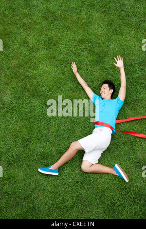 Kreative junge Mann imitieren ausgeführten Angriff auf Rasen Stockfoto