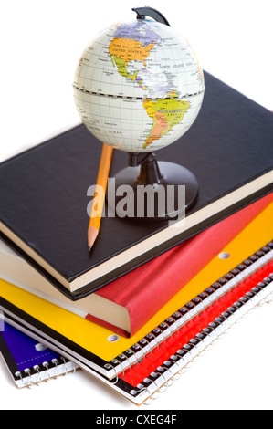 Ein Stapel von Schulbüchern und eine Miniatur-Kugel auf einem weißen Hintergrund mit einem Bleistift Stockfoto