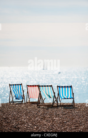 Vier leere Liegestühle am Brighton Beach in East Sussex in Großbritannien. Stockfoto