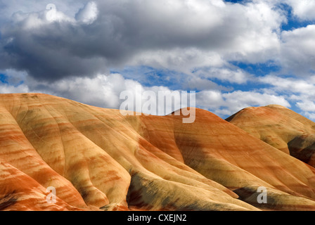 Horizontale Landschaft aus bunten Painted Hills in Oregon gegen bewölkten blauen Himmel. Stockfoto