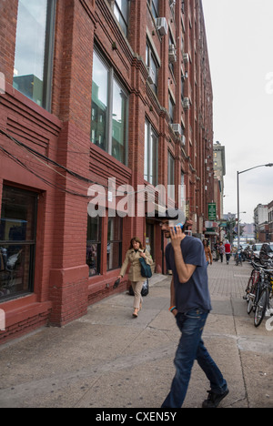 New York City, NY, USA, Straßenszenen, Menschen zu Fuß, DUMBO-Gegend, Brooklyn, Gentrifizierung der Stadtgebiete in den USA, brooklyn Loft außen, Mann zu Fuß in der Stadt mit Smartphone Stockfoto