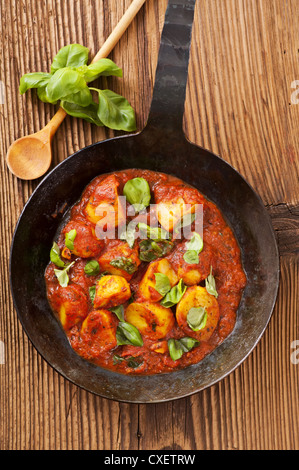 Kartoffel-Pizzaiola mit frischem Basilikum Stockfoto