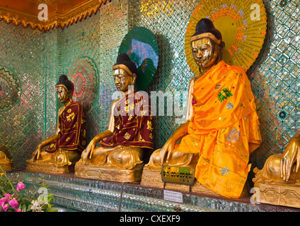 Drei bekleidet BUDDHAS an die SHWEMAWDAW PAYA ist eine 1000 Jahre alte und 114 Meter hoch - BAGO, MYANMAR Stockfoto