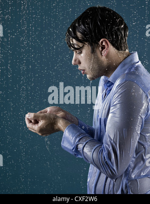 Kaukasischen Mann unter der Dusche in der Kleidung Stockfoto
