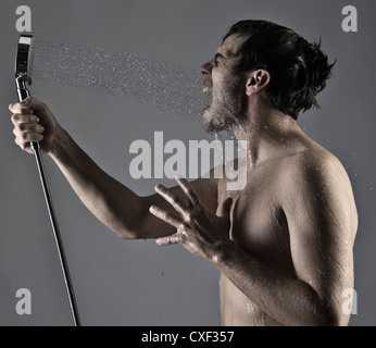 Kaukasischen Mann selbst ins Gesicht Spritzen, mit Dusche Stockfoto