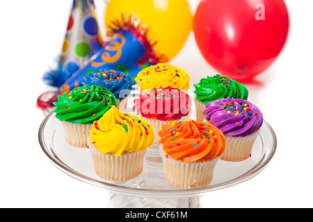 Bunten mattierte Cupcakes mit Partyhüte und Luftballons im Hintergrund Stockfoto