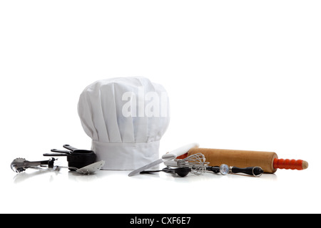 Kochmütze mit Kochutensilien auf weißem Hintergrund Stockfoto