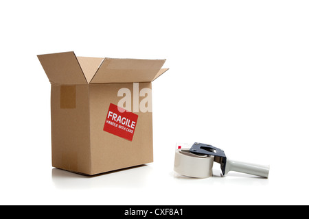 Versand-Box mit fragile Aufkleber und Tape gun Stockfoto