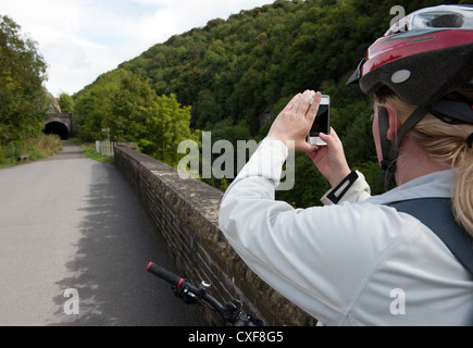 Weibliche Radfahrer stoppt, um auf den Spuren der Monsal im Peak District, Derbyshire, England, UK mit dem Handy fotografieren. Stockfoto