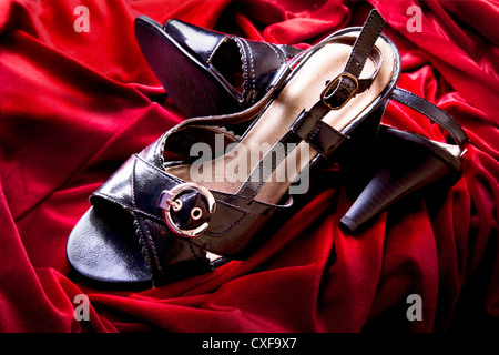 Stylischen Sandaletten für Damen auf rotem Samt. Stockfoto