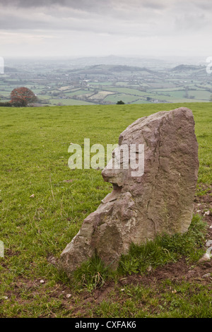 Ein stehender Stein auf Hirsche Leap in Somerset. Regenwolken ist über Glastonbury Tor im Hintergrund zu sehen. Stockfoto