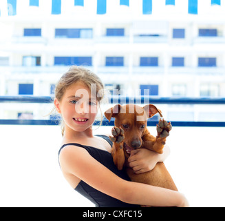 Brünette junge Mädchen mit Sommer Badeanzug spielen mit Hund in Wohnung Stockfoto