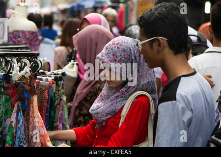 Eine junge Sinapore muslimische Frau trägt Hijab (Kopftuch) Shop für Kleidung in einem Straßenmarkt in Kuala Lumpur, Malaysia Stockfoto