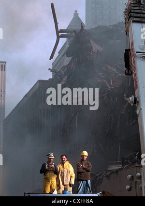 Feuerwehrleute zusehen, wie US-Präsident George W. Bush befasst sich Rettungskräfte an der zerstörten World Trade Centers 14. September 2001 in New York City. Bush Erholung Arbeiter gerichtet und sammelten sich die Nation nach Terroranschlägen. Stockfoto