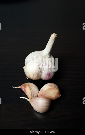 Zopf von Knoblauch Zwiebeln Nahaufnahme auf schwarzem Hintergrund Stockfoto