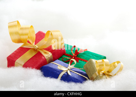 Bunte Weihnachtsgeschenke auf weißer Baumwolle, der aussieht wie Wolken (selektiven Fokus, Fokus auf die blaue und goldene Geschenk-Boxen) Stockfoto