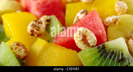 Gesüßte gepuffter Weizen Getreide auf frisches und gesundes Obstsalat mit Wassermelone, Mango, Kiwi und Banane Stockfoto