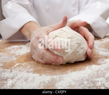 Einer Frau die Hände kneten den Teig auf ein Schneidebrett Stockfoto