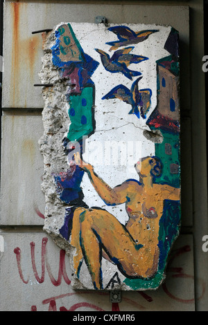 Ein Stück des Graffiti bedeckt Berliner Mauer auf dem Display in der Nähe von Checkpoint Charlie Stockfoto