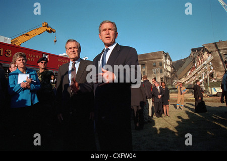 US Präsident George W. Bush liefert Bemerkungen vor das beschädigte Pentagon 12. September 2001 in Arlington, VA. Der Präsident ist von Karen Hughes, Berater des Präsidenten, und US-Verteidigungsminister Donald Rumsfeld begleitet. Am 11. September American Airlines Flug 77 von Terroristen fliegen in das Gebäude töten alle 64 Passagiere an Bord entführt und 125 Menschen auf dem Boden. Stockfoto