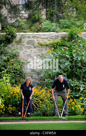 Gärtner mit Einfassung Scheren arbeiten entlang eines Pfades Worcester College in Oxford Stockfoto