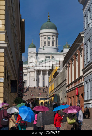 Kathedrale von Helsinki in den Senatsplatz mit Touristen im Vordergrund holding Sonnenschirme gegen starke UV-Helsinki Finnland zu schützen. Stockfoto