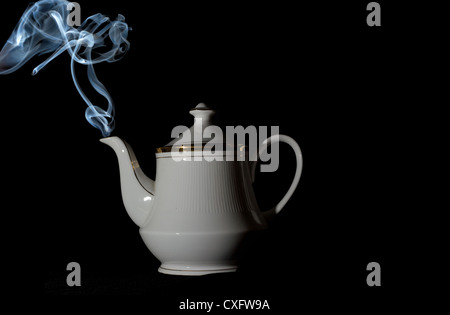 Rauch aus isolierten Teekanne auf schwarzem Hintergrund Stockfoto