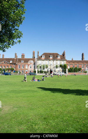 Menschen sitzen auf dem Rasen auf Choristers Grün in der Kathedrale nahe Salisbury Wiltshire UK an einem Sommertag Stockfoto