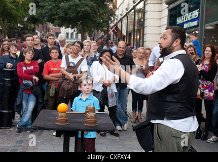 Ein junges Kind gerade eine Straße Entertainer durchführen, Covent Garden, London UK Stockfoto