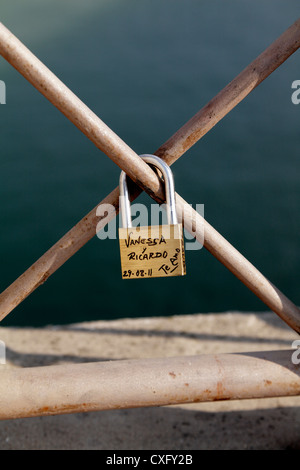 Liebe token Vorhängeschloss mit ein paar Namen auf dem Geländer der Isabella II Brücke über den Fluss Guadalquivir eine einzige Stockfoto