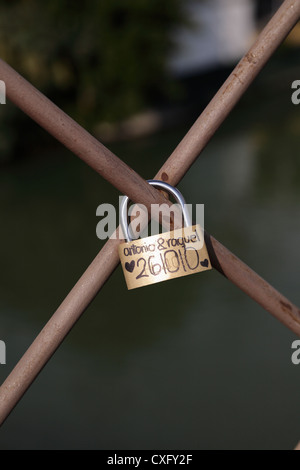 Liebe token Vorhängeschloss mit ein paar Namen auf dem Geländer der Isabella II Brücke über den Fluss Guadalquivir eine einzige Stockfoto