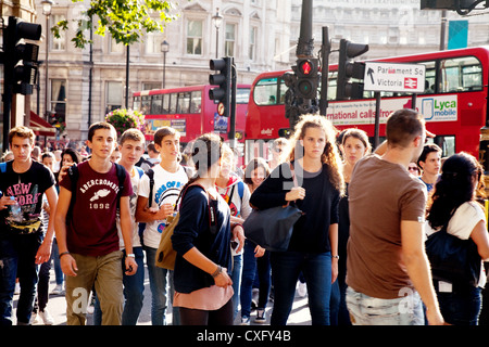 Britische Menschen in London England; Eine Menge Fußgänger, die die Straße überqueren, Trafalgar Square, London WC2, London City Centre, London UK Stockfoto