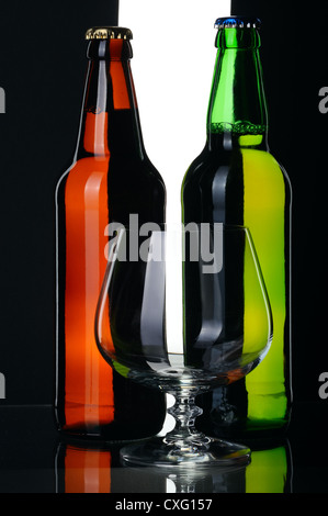 Flaschen Lagerbier aus grünen und braunen Glas, auf einem schwarzen und weißen Hintergrund isoliert. Stockfoto