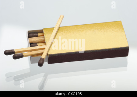 Goldene Schachtel Streichhölzer auf der Glasoberfläche Stockfoto