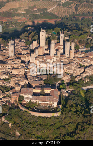 LUFTAUFNAHME. Mittelalterliche Stadt auf einem Hügel mit ihren vielen Türmen, die vor Jahrhunderten von reichen Familien erbaut wurden. San Gimignano, Provinz Siena, Toskana, Italien. Stockfoto